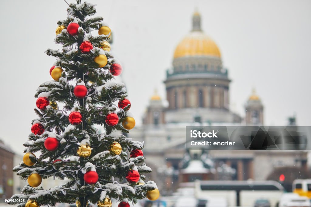 Scenic view of St. Isaac's Cathedral in Saint Petersburg, Russia, on beautiful winter day Scenic view of St. Isaac's Cathedral and decorated Christmas tree in Saint Petersburg, Russia, on a beautiful winter day St. Petersburg - Russia Stock Photo
