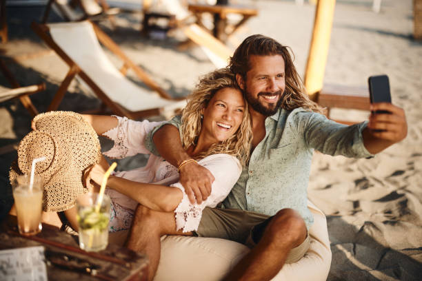 istock Happy couple taking a selfie with cell phone on the beach. 1429922995