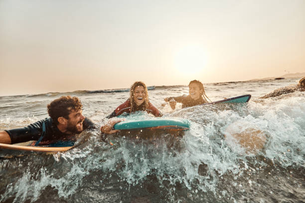 istock Cheerful friends having fun while surfing at sunset. 1429924003
