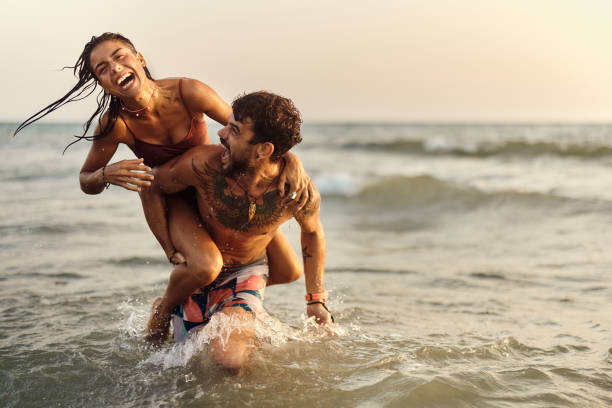 istock Cheerful couple having fun while piggybacking at sea. 1429924176