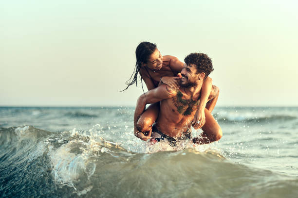 istock Young playful couple having fun while piggybacking at sea. 1429924639