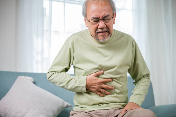 istock Elderly Asian old man sitting on sofa having stomachache 1429925120