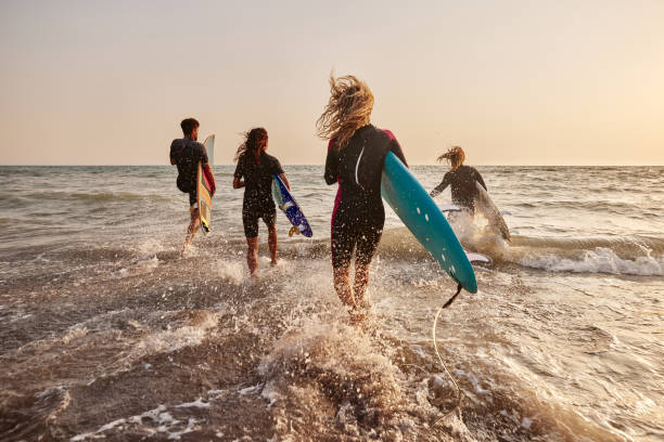 se précipiter vers le surf! - exercising wetsuit people expressing positivity photos et images de collection
