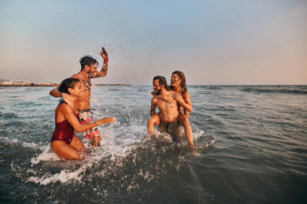 istock Young cheerful couples having fun during summer vacation in sea. 1429926389
