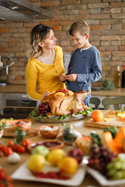 istock Happy single mother and her son decorating Thanksgiving turkey. 1429927343