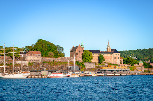 Oslo, Norway - August 13 2022: Akersus Fortress seen from the sea (Oslofjord) in a summer afternoon