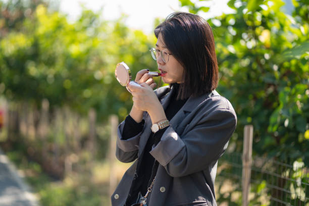 istock woman applying makeup outdoors 1429929198