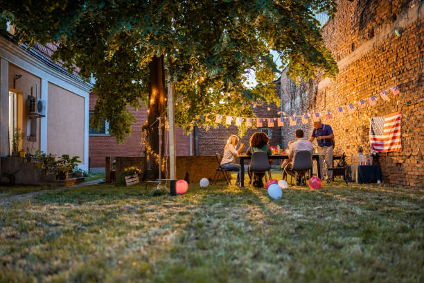 A multi-generation multiracial family having dinner outdoors on an American national holiday