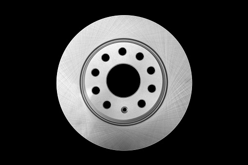 Car brake disc isolated on black background. Auto spare parts. Perforated brake disc rotor isolated on black. Braking ventilated discs. Quality spare parts for car service or maintenance