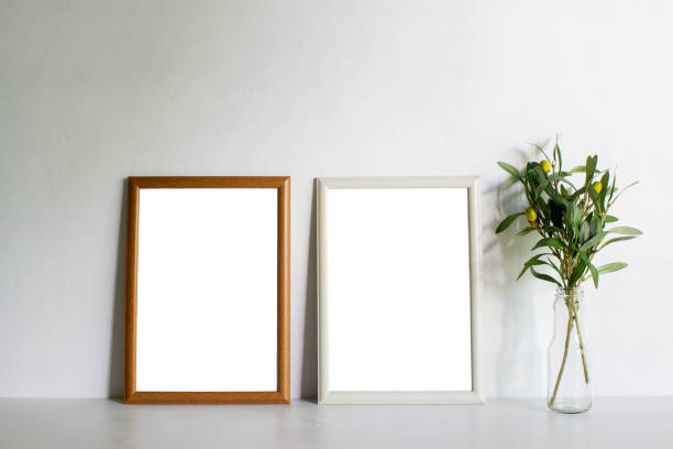 istock Wooden frames and green leaves on table with natural light. 1429932330