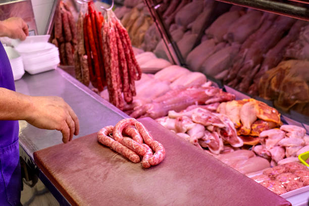 istock Butcher working with sausage serving customers. 1429932561