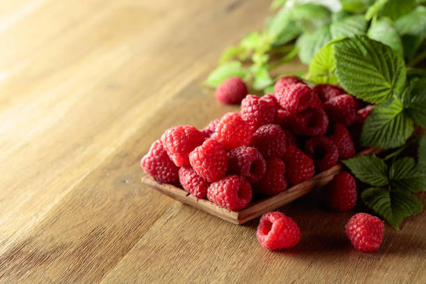 istock Ripe juicy raspberries with leaves. 1429936978