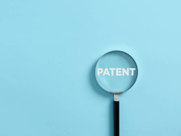 a lupa se concentra na palavra patente. conceito de patenteamento ou proteção de direitos autorais - propriedade intelectual - fotografias e filmes do acervo