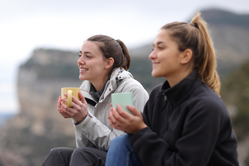 Two trekkers drinking coffee in the mountain