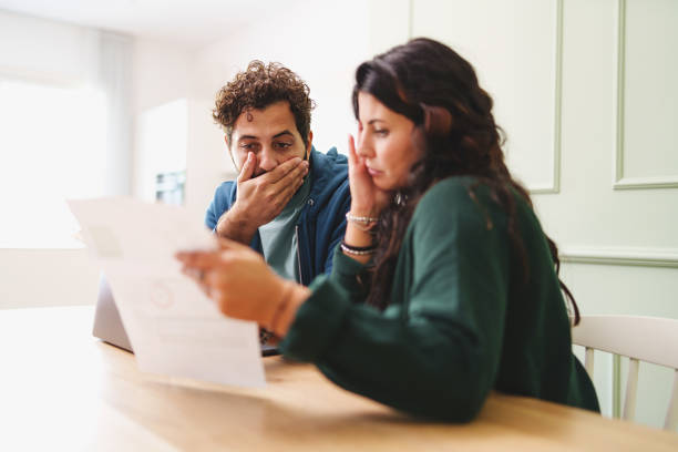 un jeune couple marié s’inquiète en regardant la facture d’électricité ou l’arrivée de taxes très chères - debt photos et images de collection