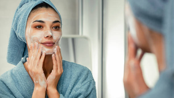 reflet dans un miroir belle femme se lavant le visage - face mask photos et images de collection