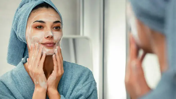 Photo of Reflection in a mirror beautiful woman washing her face