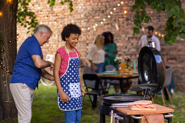 istock Grandfather tying his granddaughter's apron at a back yard barbecue party 1429952392