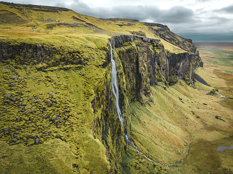 Drífandi waterfall is about 70 meters high waterfall near Seljalandsfoss waterfall in Iceland. Aerial shot with cloudy sky.