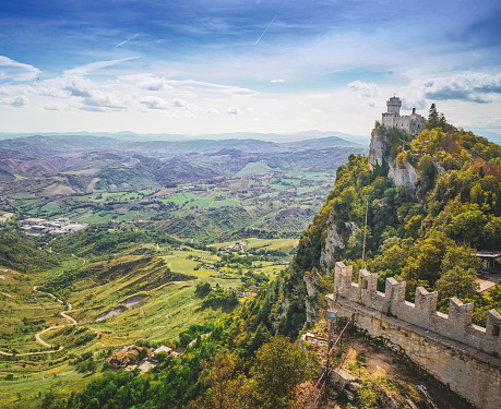 A panoramic view from San Marino with a tower perched on the edge of a cliff