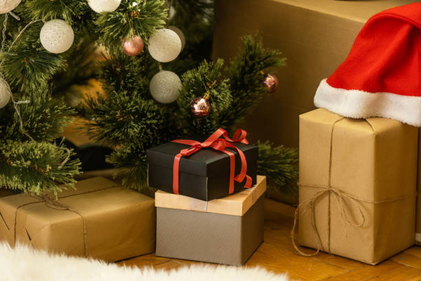 istock Beautiful Christmas gift boxes on floor near fir tree in room. 1429953789