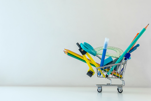 brushes in a row with faces and funny grimace over white wooden background, top view, above