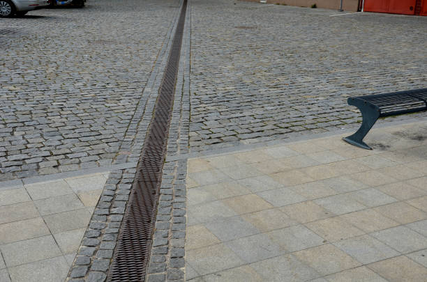 istock across the path there is a channel with a metal grid for drainage interlocking paving. the water is drained from the surface into the gutter and further into the rain sewer 1429962063