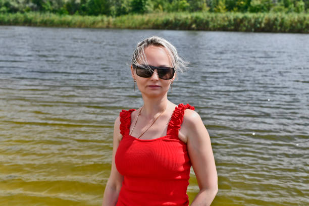Beautiful woman with a tame hamster in her arms near the river.