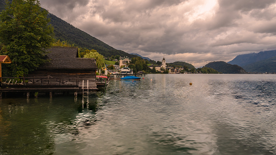 Portschach, Austria - 1 July 2018: Sunchairs on wooden pier and view of beautiful alpine lake Worthersee on Austria