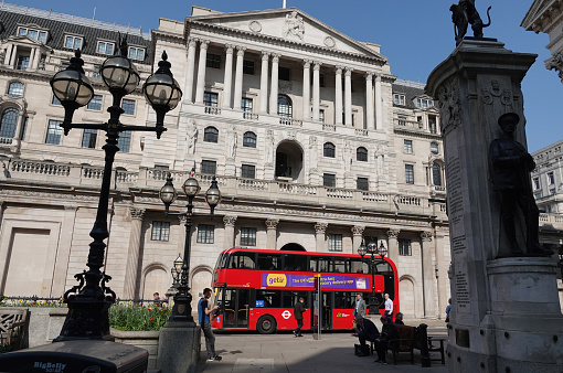 London, UK - March 23, 2022: The Bank of England in the City of London with a red London Bus in the foreground.