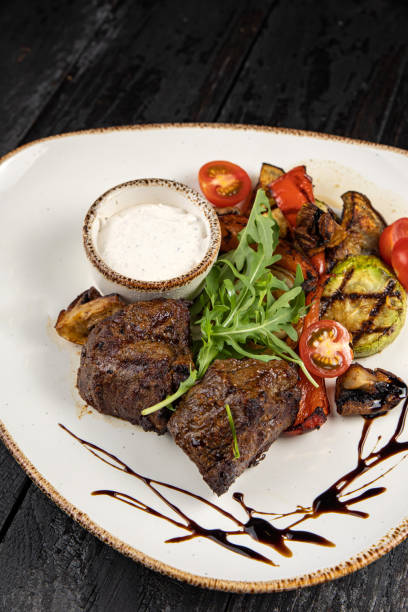 istock grilled meat with vegetables and spices on a black background 1429963828