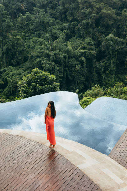 istock Young woman standing by swimming pool 1429965282