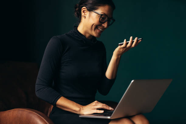 istock Smiling woman speaking on cellphone and working on laptop 1429965756