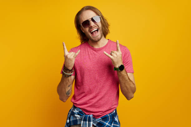 istock Excited young man gesturing and smiling while standing against yellow background 1429966592