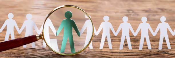 istock Magnifying Glass On Cut-out Figures 1429967637