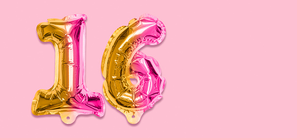 Rainbow foil balloon number, digit sixteen on a pink background. Birthday greeting card with inscription 16. Top view. Numerical digit. Celebration event, template. Banner.
