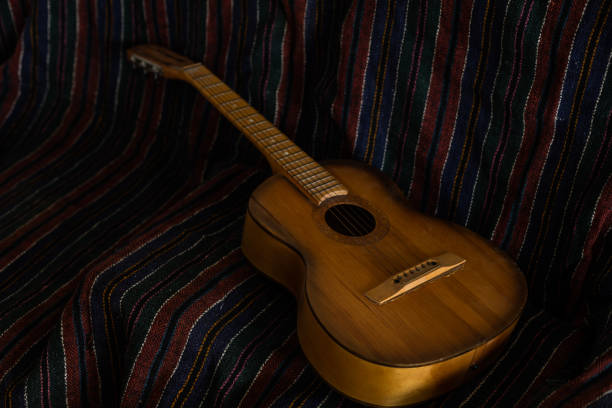 Looking down at the mid-section of a Spanish guitar with intricate decorative inlay.