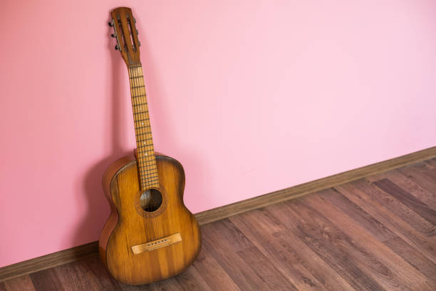 istock classic guitar lying in front of a wall as background 1429970815