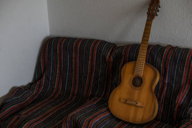 istock old acoustic guitar on an old armchair horizontal 1429970906