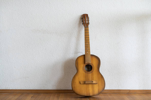 istock classic guitar lying in front of a wall as background 1429970979