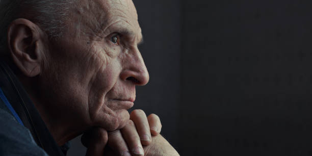 Sad widowed senior man with pensive look seated at home Side view of sad widowed senior man with pensive look. Mental health and grandparents care. old man depressed stock pictures, royalty-free photos & images