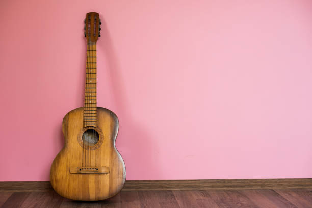 classic guitar lying in front of a wall as background