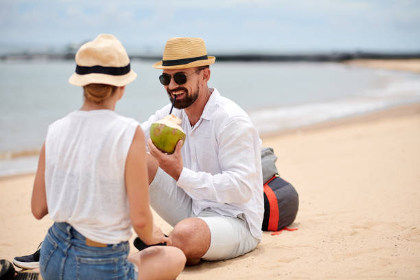 istock Happy couple relaxing on the beach with coconuts 1429973855