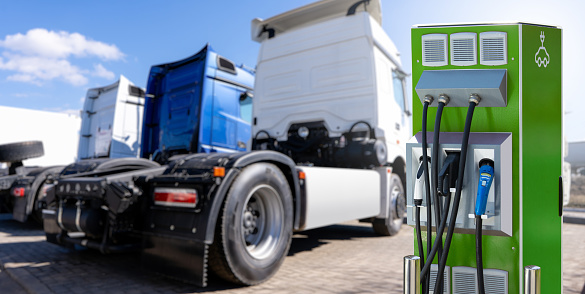 Electric vehicles charging station on a background of a trucks