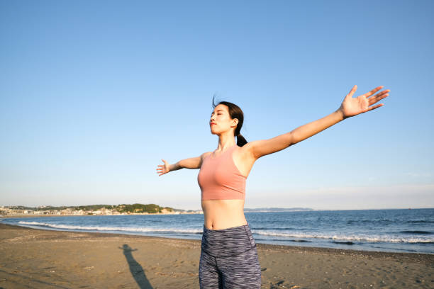 istock Yoga instructor opening arms on beach 1429975560
