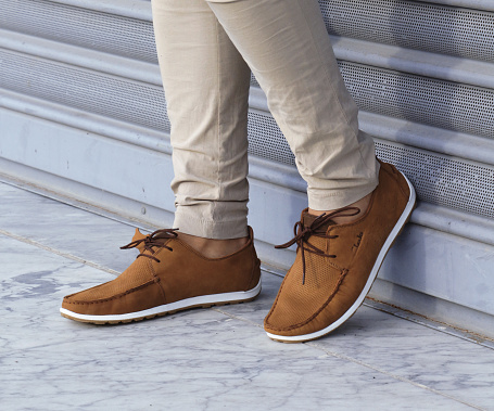 Casual man brown loafer shoes posing in the urban street.