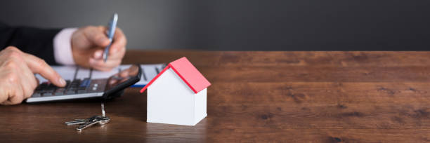 istock Businessman Calculating House Costs Using Calculator 1429977873
