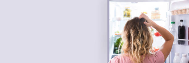 istock Confused Woman Looking In Open Refrigerator 1429979055