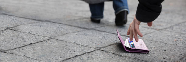 istock Man Picking Up A Lost Purse 1429979703