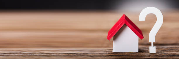 istock Small Model House By Question Mark On Wood 1429980068